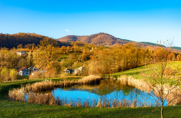 Beautiful autumn landscape with traditional houses and a lake in Sighetu Marmatiei, Maramures region - Romania