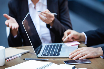Image of hands of bisiness man using pencil and using laptop and wifi connection discussing with partner to plan the project on desk in workplace. Selective focus