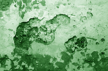 Сraked weathered cement wall texture in green tone.