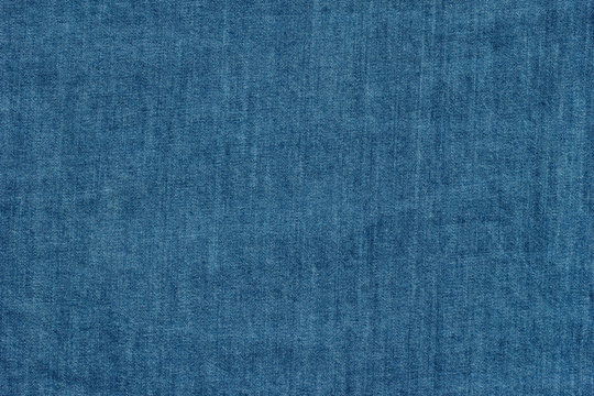 Old blue denim jeans texture or background with visible fibers 