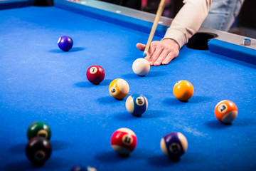 Close-up of a man's hand playing pool