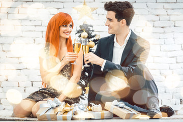 Couple drinking sparkling wine on Christmas looking at each other