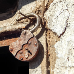 old rusty lock nailed to a wall