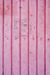 7131474 An old distressed wooden vertical plank texture with dry peeling pink paint