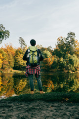 rear view of traveller with backpack on autumnal background