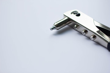 Detail of an old rivet gun (hand riveter) with rivets on a white background