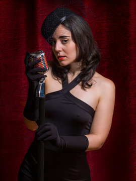 Young vintage singer, behind a microphone