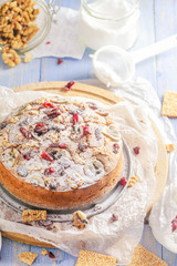 Banana cake with nuts, sesame and cranberry on a wooden table