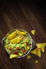 Bowl guacamole corn chips wooden table