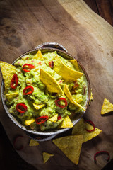 Bowl guacamole corn chips wooden table