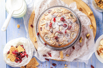 Delicious banana cake with nuts, sesame and cranberry on a wooden table