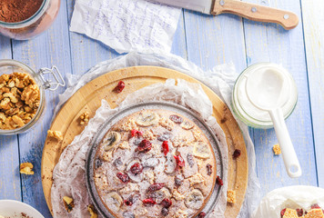 Delicious banana cake with nuts, sesame and cranberry on a wooden table