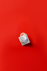 top view of condom in silver packaging on red background