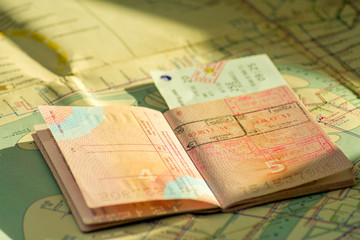 The concept of travel. Russian passport with visas. Passport and plane ticket is on the old map. Sunlight and shadow