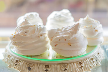 white air meringues on display plate at pastry shop