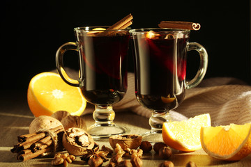Two cups with ready mulled wine with anise, cinnamon and nuts around