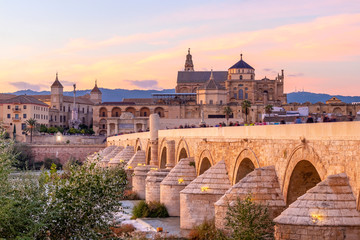 Long exposure photography of Mosque-Cathedral and the Roman Bridge at sunset in Cordoba, Andalusia, Spain