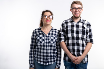 Nerds, geek, bespectacled and funny people concept - funny couple in glasses are hugging on white background