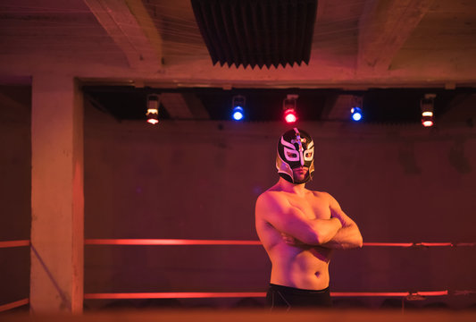 Confident man in wrestling mask on ring