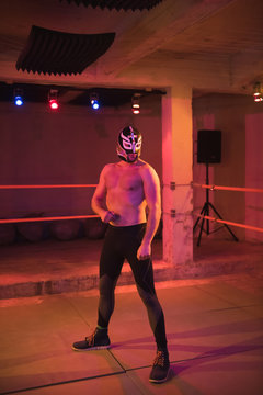 Confident man in wrestling mask on ring
