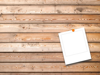 Blank square instant photo frame with orange pin on brown wooden boards background