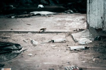 Old abandoned house and used plastic syringes. The problem of drug addiction in society