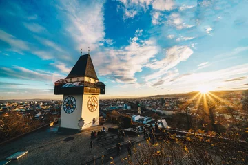 Fototapeten Graz clock tower and city symbol on top of Schlossberg hill at sunset © Calin Stan