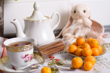 Decorative orange mandarins, tangerines, cup of tea, home mandarins, small mandarines.