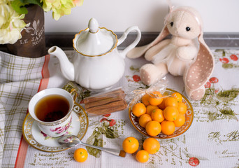 Decorative orange mandarins, tangerines, cup of tea, home mandarins, small mandarines.