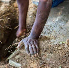 Black hands doing manual labor digging in the soil image with copy space