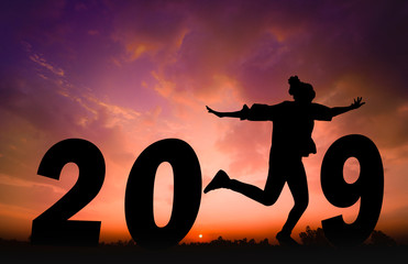 Happy new year Silhouette sunset background.She standing and jump instead  number 1 word. She standing between 20 and 9.new year,success ,2019, Photo Silhouette and new year  concept idea.