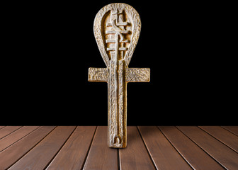 Ankh symbol. Egyptian cross on a wooden table and black background