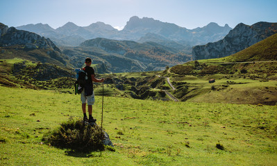 Obraz premium Mountaineer looking beautiful landscape with path between mountains on a sunny day