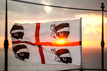 Bandiera dei quattro mori della Sardegna, su sfondo cielo al tramonto - obrazy, fototapety, plakaty