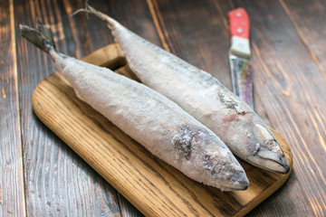 Frozen mackerel fish on wooden background.