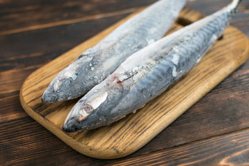 Frozen mackerel fish on wooden background.