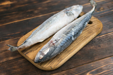 Frozen mackerel fish on wooden background.