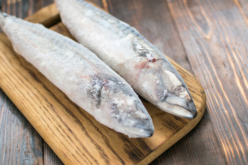 Frozen mackerel fish on wooden background.