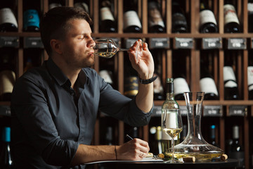 Sommelier degustating white wine by drinking it