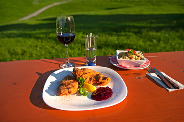 Wiener Schnitzel mit Kartoffelsalat serviert auf einer Alm im Bregenzerwald