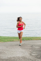 Young fit latin female athlete running