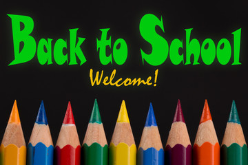 Back to School welcome, quote on Tips of Colored pencils, black background. 