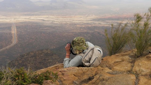 Photographer In The Mountains Lies In A Comfortable Position To Take A Photo