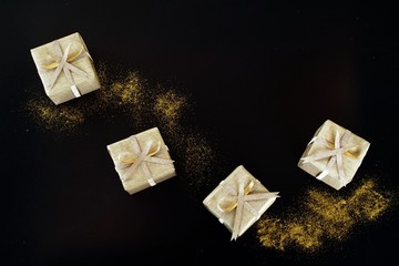 Golden wrapped gift boxes on black background.