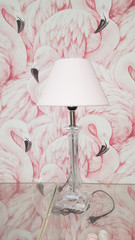 standing lamp posed in front of a flamingo wall