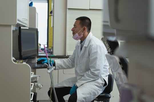 Male dentist using desktop pc in clinic
