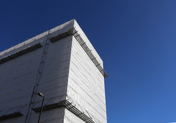 Building wrap wrapped white facade under construction