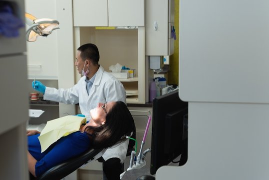 Male Dentist Examining A Lady Patient