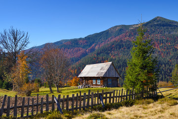 Beautiful landscape with old wooden hut in the Carpathians mountains. Autumn sunny day.