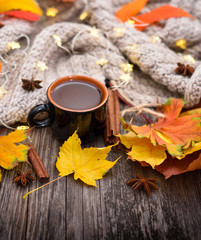 Obraz na płótnie Canvas Autumn composition. Fall leaves, cup of coffee and scarf on old wooden background.